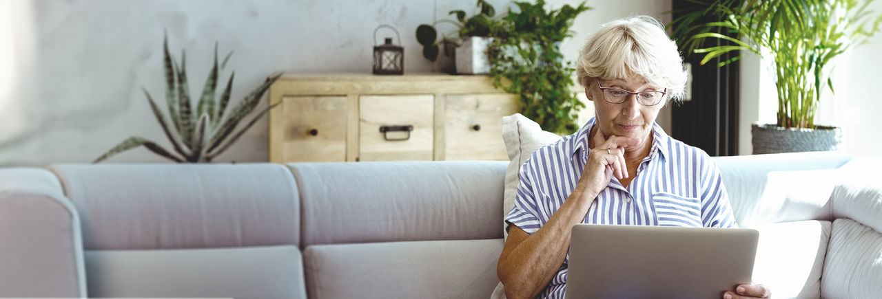 Middle aged woman reading, referring to Frequenty asked questions.